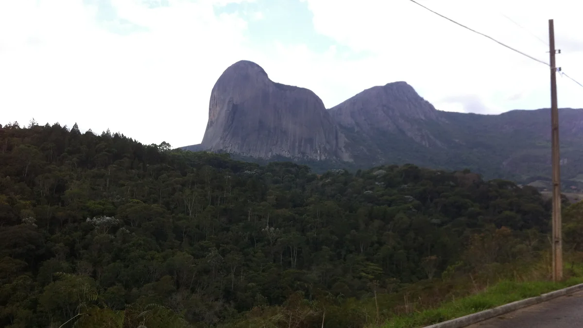 A Pedra Azul vista de estrada próxima, com mata em primeiro plano