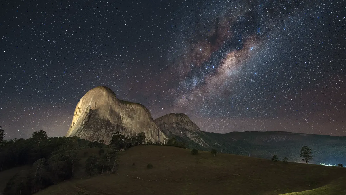 Céu noturno estrelado sobre a Pedra Azul, na região serrana capixaba